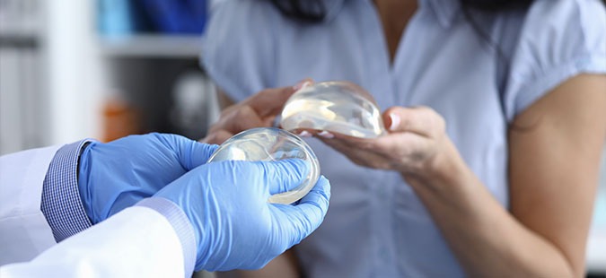 doctor-showing-breast-implants-during-consultation-with-woman