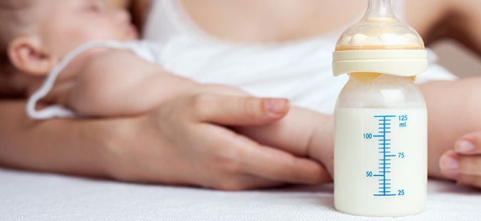 mother holding baby and baby bottle